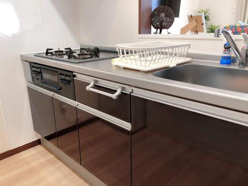 a kitchen with a sink and a stove at TerraceRin YN22 in Tomigusuku