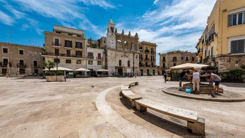 a group of people standing in a plaza with benches at Suite Whiteflower in Bari
