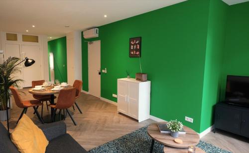 a living room with a green wall and a table at Luxury 60m2 Apartment with 20m2 Private Terrace - R65A in Eindhoven