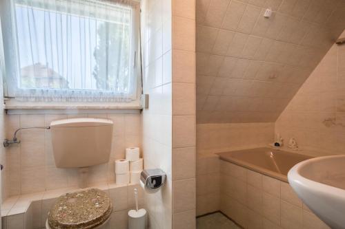 ein Badezimmer mit Toilette, Waschbecken und Badewanne in der Unterkunft Haus Bea in Rickenbach