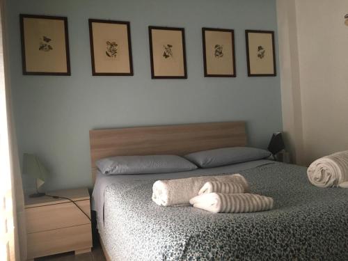 ein Schlafzimmer mit einem Bett mit vier Bildern an der Wand in der Unterkunft Alla Rotonda dai Santi in Rovigo