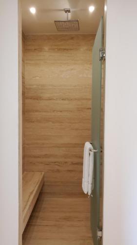 a bathroom with a shower with a wooden wall at Hotel Secreto in Isla Mujeres