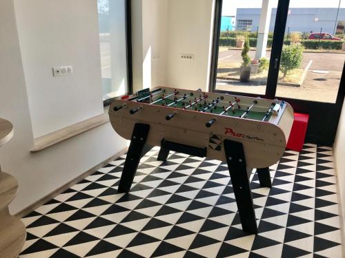 a foosball table sitting on a checkered floor at ibis Haguenau Strasbourg Nord in Haguenau