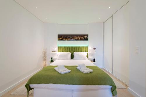 a bedroom with a large bed with white walls at Heart of D. Pedro Apartments III in Porto
