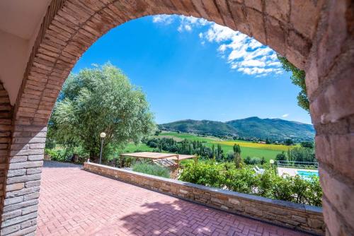 an archway in a building with a view of a field at Abadia Farneto in Gubbio