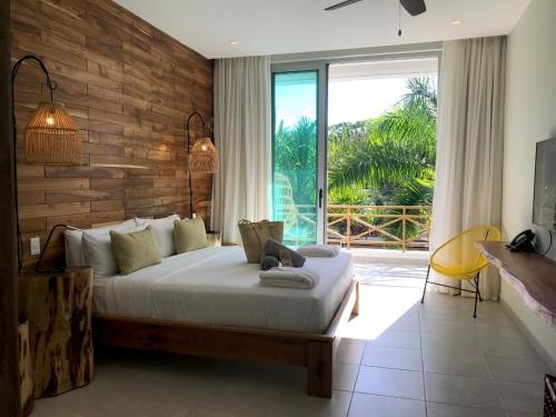 a bedroom with a large bed and a large window at Saman Boutique Hotel in Las Terrenas