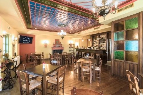 un restaurante con mesas y sillas y un bar en Ameliko Zagori en Ano Pedina