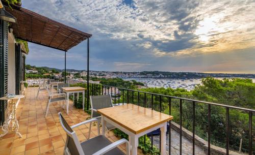 a balcony with tables and chairs and a view of the water at Hotel Rec de Palau in Cadaqués