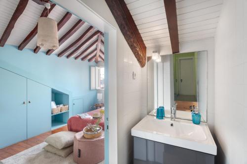 baño con lavabo y sala de estar. en Own Places Clérigos Apartments, en Oporto