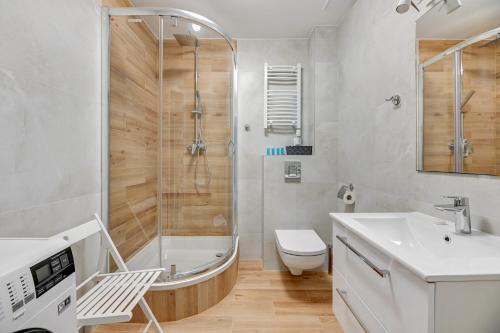 a bathroom with a shower and a toilet and a sink at Blue Mandarin Apartments II in Sopot