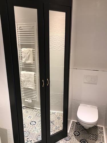 a bathroom with a toilet and a glass door at Brussel House Basilic in Brussels