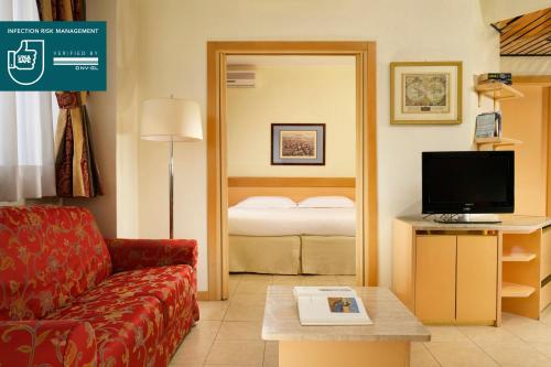 
a hotel room with a bed, television and a desk at UNAWAY Hotel & Residence Quark Due Milano in Milan
