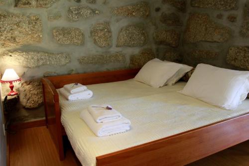 a bedroom with a bed with towels on it at Quinta Santo António Amares in Braga