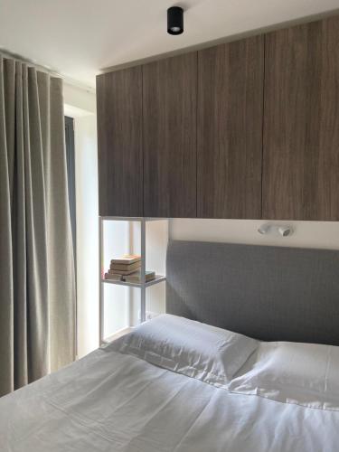 um quarto com uma cama e um armário de madeira em Apartment KORA em Pervalka