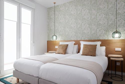 2 camas blancas grandes en un dormitorio con ventanas en MARCIAL SUITE Central, modern and NEW., en San Sebastián