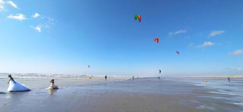 a bride and groom walking on the beach with kites at Le clapotis de l'Ô, calme, balcon sur la mer, à 2 h de Paris in Ault
