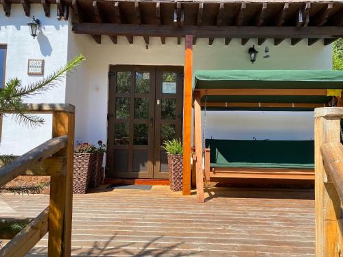 a porch of a house with a green awning and a door at Cabana Cota 1000 Arieseni in Arieşeni