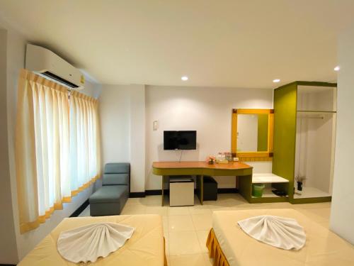 a living room with a table and a desk in a room at Polkadot Hostel in Phitsanulok