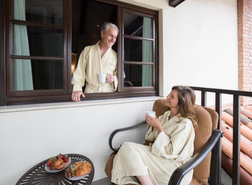 a woman sitting in a chair on a balcony with a man at Roman Spa Resort in Calistoga