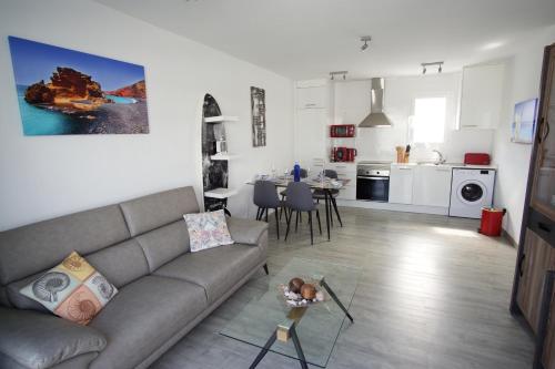 a living room and kitchen with a couch and a table at Apartment Cucharas Beach - Pool - Beach 2 min - Free AC & Wifi in Costa Teguise