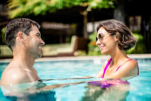 a man and a woman in a swimming pool at Roman Spa Resort in Calistoga