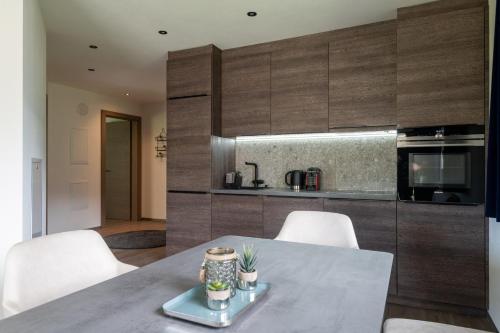 a kitchen with a table and white chairs in a room at Freiraum 9 Living Apartment in Sankt Johann im Pongau