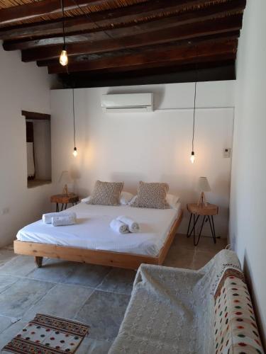 a bedroom with a large bed with two chairs at Saint Antonio Maroni in Maroni