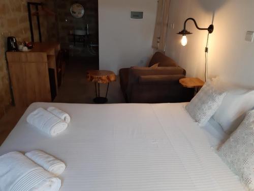 a large white bed in a room with a couch at Saint Antonio Maroni in Maroni