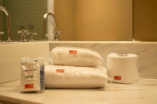 two rolls of toilet paper sitting on top of a bathroom sink at eSuites Savassi Toscanini in Belo Horizonte