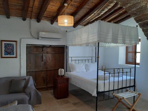 a bedroom with a canopy bed and a couch at Saint Antonio Maroni in Maroni
