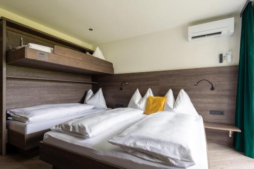 a bedroom with two beds with white pillows at Freiraum 9 Living Apartment in Sankt Johann im Pongau