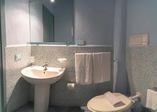 a bathroom with a sink and a toilet and a mirror at Solares Case Vacanze in Ustica