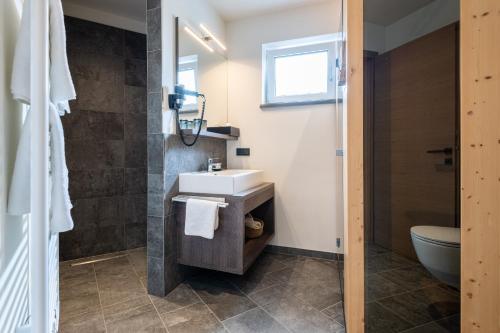 a bathroom with a sink and a toilet at Freiraum 9 Living Apartment in Sankt Johann im Pongau