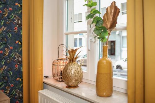 a window sill with vases and plants on it at Sleepwell Apartment - Emilienblick in Leipzig