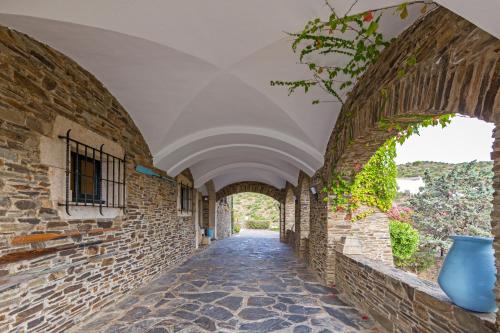 an empty hallway in an old building with an archway at Hotel Rec de Palau in Cadaqués