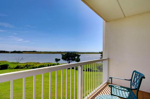 a balcony with a bench and a view of the water at Epworth By The Sea in Saint Simons Island