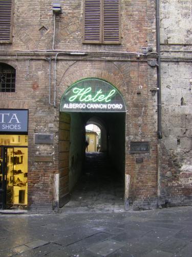 a brick building with a sign over a tunnel at Albergo Cannon d'Oro in Siena