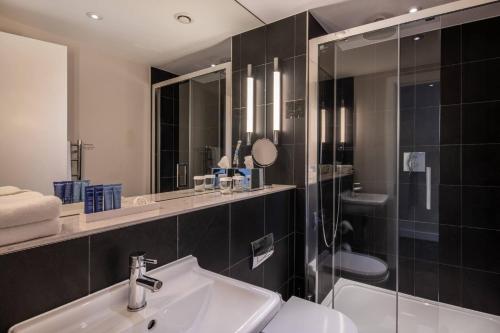 a bathroom with a sink and a shower at The Resident Soho in London