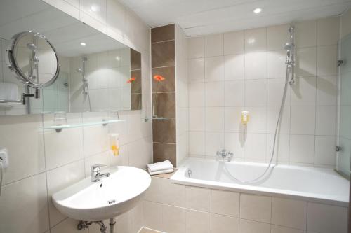 a bathroom with a sink and a shower and a tub at Best Western Hotel Rosenau in Bad Nauheim