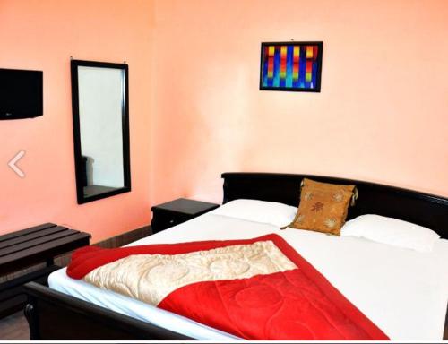 a bedroom with a bed with a red blanket on it at 5 Elements Hotels in Uttarkāshi