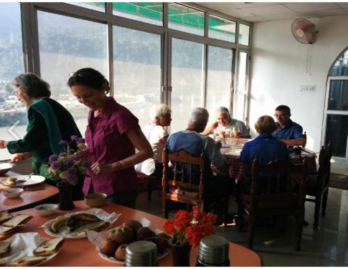 a group of people sitting around a table in a room at 5 Elements Hotels in Uttarkāshi