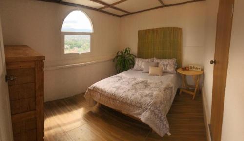 a bedroom with a bed and a window and a table at Terraza Cielito Lindo in Oaxaca City