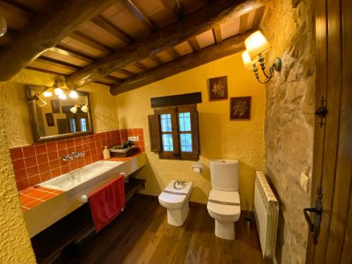 y baño con 2 aseos, lavamanos y bañera. en Casa Rural Can Mananna Lloguer íntegre, en Sant Feliu de Buixalleu