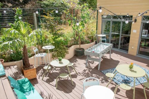 a patio with tables and chairs and plants at The People - Paris Bercy in Paris