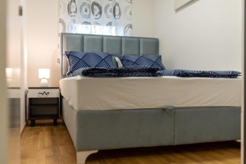 a bedroom with a large bed with blue pillows at Danijela Apartment in Novi Sad