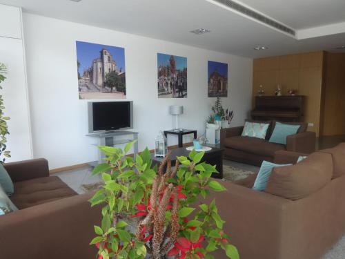 a living room with couches and a flat screen tv at Hotel Bonjardim in Tomar
