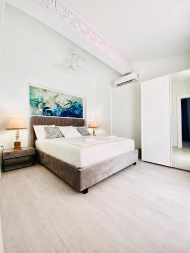 una camera da letto bianca con un letto e un quadro sulla parete di SANDY BAY Villa a Ayia Napa