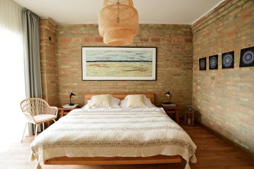 um quarto com uma cama grande e uma parede de tijolos em Art Gallery Apartment em Nové Zámky