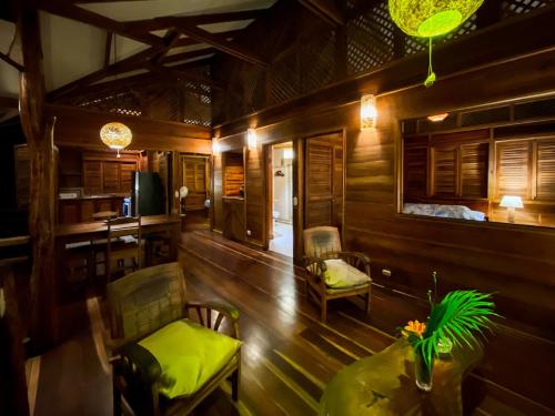 a living room with wooden walls and a table and chairs at Finca Chica Lodge & Villas in Puerto Viejo