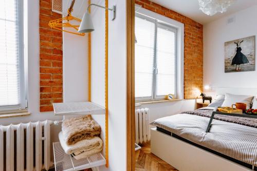 - une chambre avec un lit et un mur en briques dans l'établissement KOZAcki Kwadrat, à Lublin